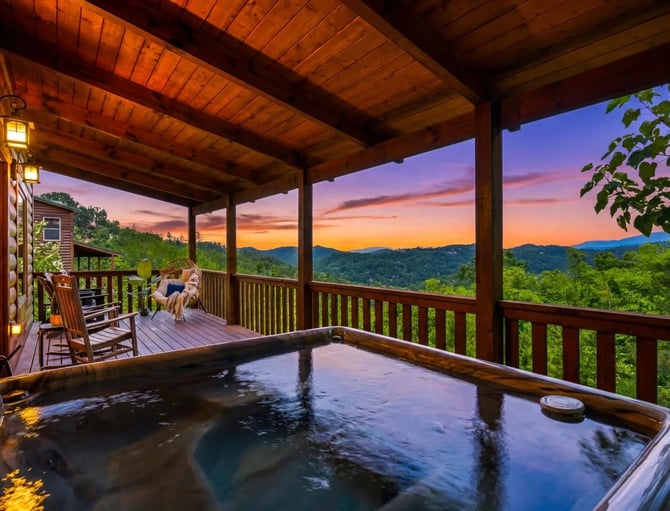 Hot tub on wooden deck with mountain sunset view, log cabin porch with rocking chairs and forest landscape